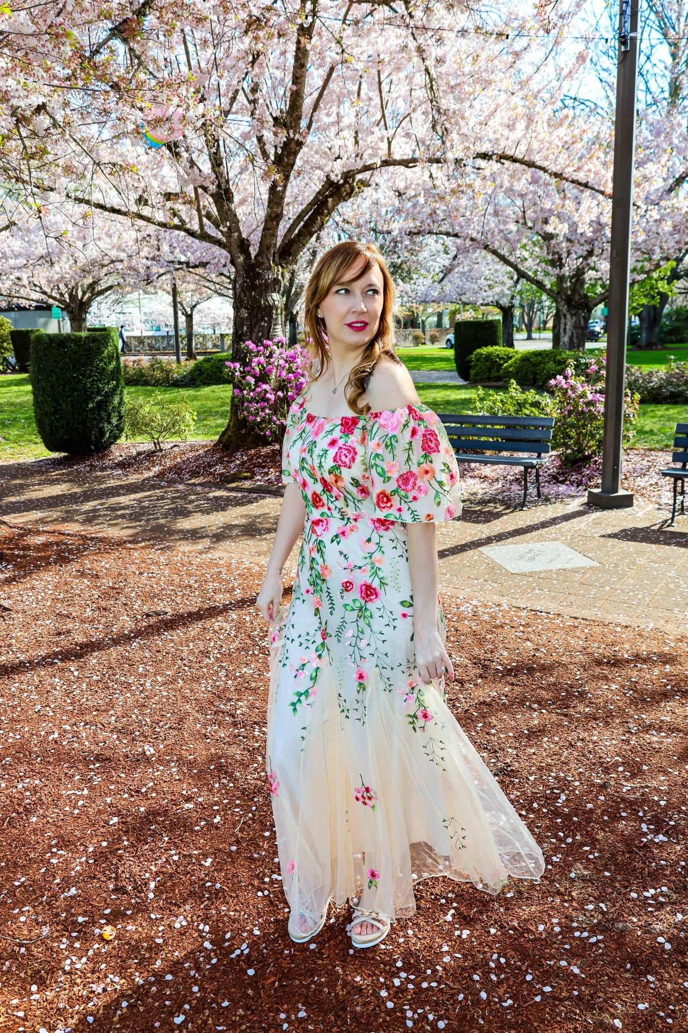 Christina Joann in a floral dress among cherry blossoms